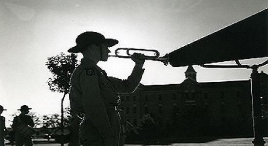 A cadet on the hilltop sounds his bugle, circa 1942-1946.